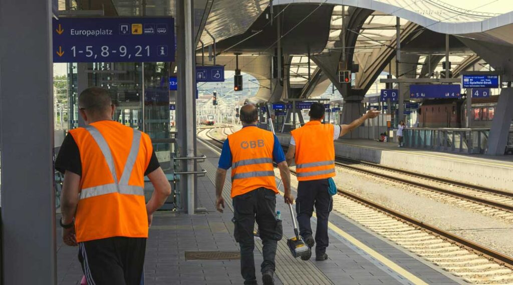 operai in stazione con gilè riflettenti