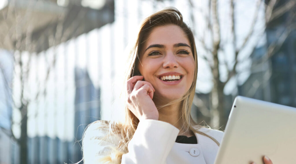 ragazza al telefono con un tablet in mano