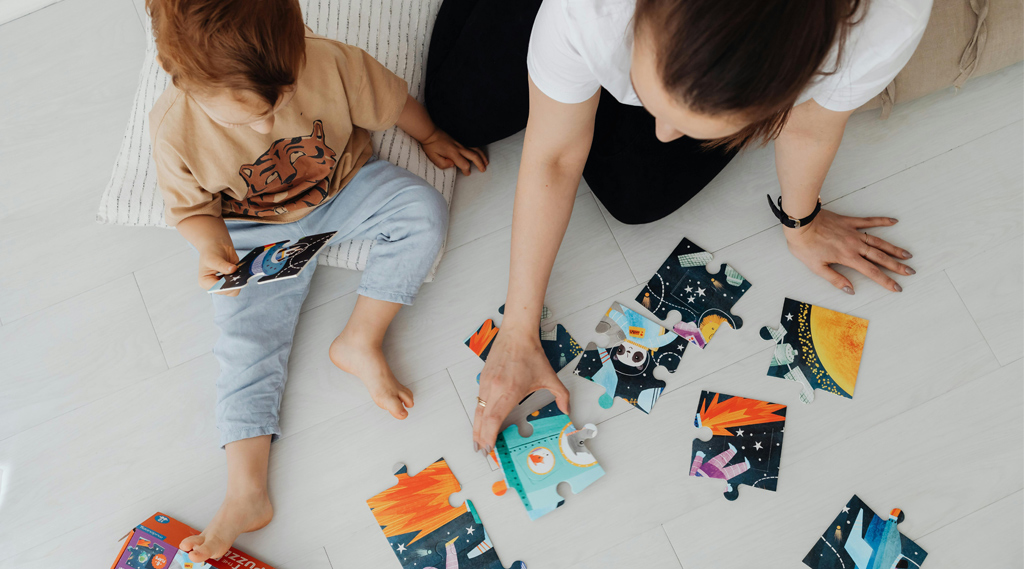 bambino che fa un puzzle con la mamma